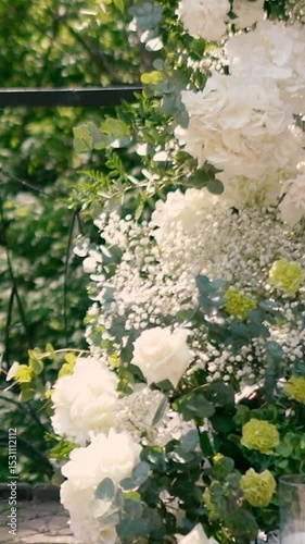 wedding arch of white rose flowers on the river bank before the wedding ceremony of the bride and groom, festive romantic decor