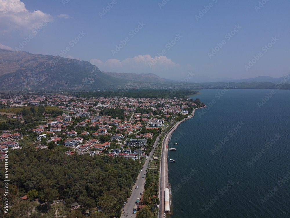Obraz premium A serene aerial view of Lake Köyceğiz in Turkey on a calm summer day, showcasing tranquil blue waters, lush surroundings, and peaceful natural beauty.