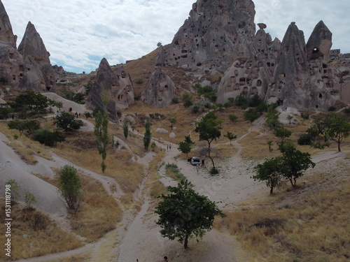 A drone view of Göreme in Cappadocia, revealing cave homes, fairy chimneys, and ancient landscapes bathed in soft light and rich earthy tones.