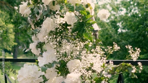 wedding arch of white rose flowers on the river bank before the wedding ceremony of the bride and groom, festive romantic decor