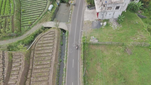 A Serene Aerial View of Agricultural Fields and a Winding Road Surrounded by Nature's Beauty