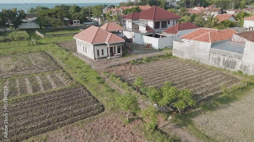 Serene Coastal Village: A Captivating View of Homes Nestled Among Fields and Rice Paddies