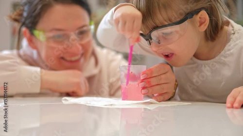 Caucasian Woman and Preschooler Daughter Child Girl Wearing Protective Glasses Having Fun Preparing STEM Science Experiment on Kitchen Table using Education Kit for Homeshooling Learning