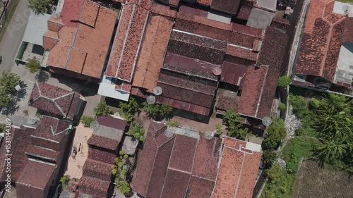 Aerial View of Traditional Houses with Unique Red Tiled Roofs and Lush Greenery Nearby