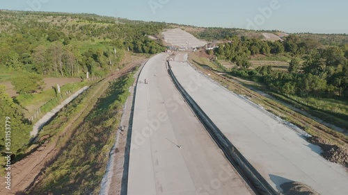 Aerial View of Construction Progress on a Newly Built Road Surrounded by Lush Green Landscapes