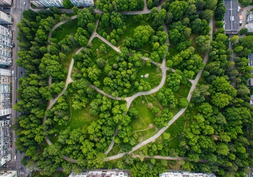 Aerial view of green city park with walking paths surrounded by buildings