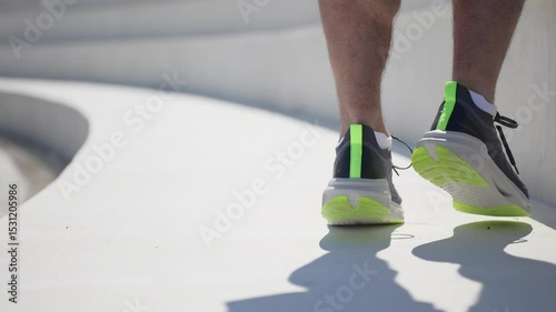 Vibrant running shoes stride on a smooth surface, celebrating the joy of exercise on a sunny day.