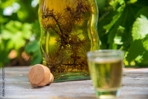 Homemade juniper brandy with mountains in the background.