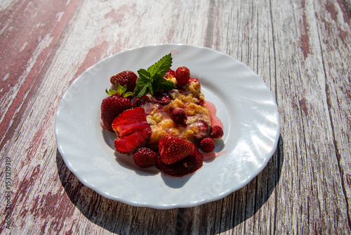 Delicious homemade strawberry bars with red topping at wooden table