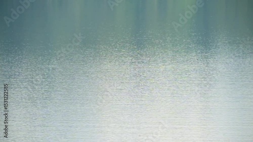 Small ripples on the surface of calm lake water. Abstract texture background of water surface. Ecology and environment concept. For transition or overlay. Footage 4K, 60Fps