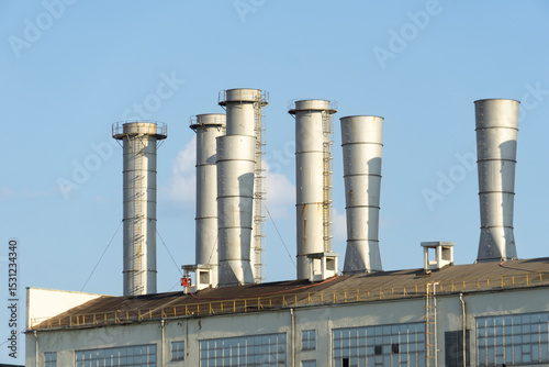 Pipes of thermal power plant on a town. Industrial zone in the city. Producing electrical energy concept.  System of electricity supply.