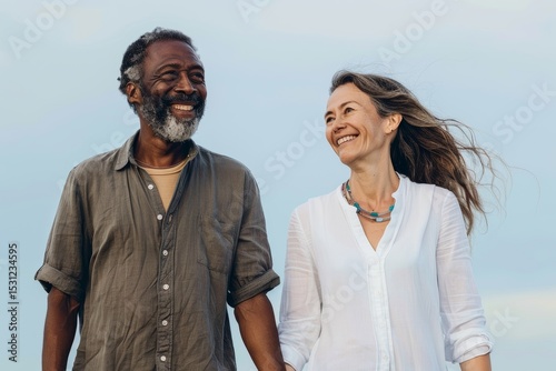 Portrait of a satisfied multiethnic couple in their 50s holding hands