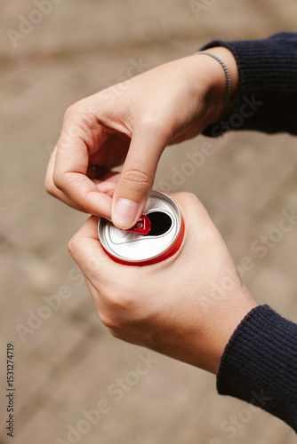 Woman opening red aluminum can with ring pull tab