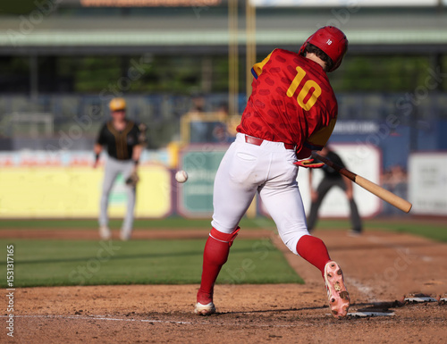 #19 baseball player hitting a low pitch