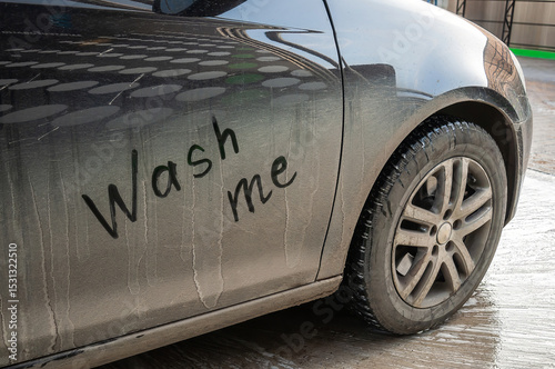 A close-up of a dirty car with a humorous request to be washed, Wash me.