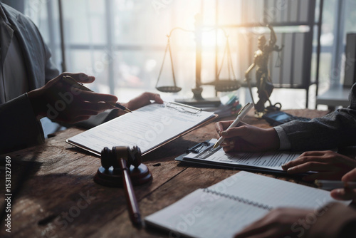 Lawyers working together on a legal document, reviewing and signing agreements in a courtroom setting, with a gavel and scales of justice in the background