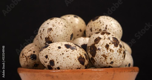 Fresh quail eggs rotates on black background. Cinema 4K 60fps close-up shot video