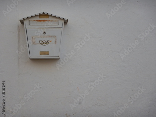 White mailbox hanging on a white wall