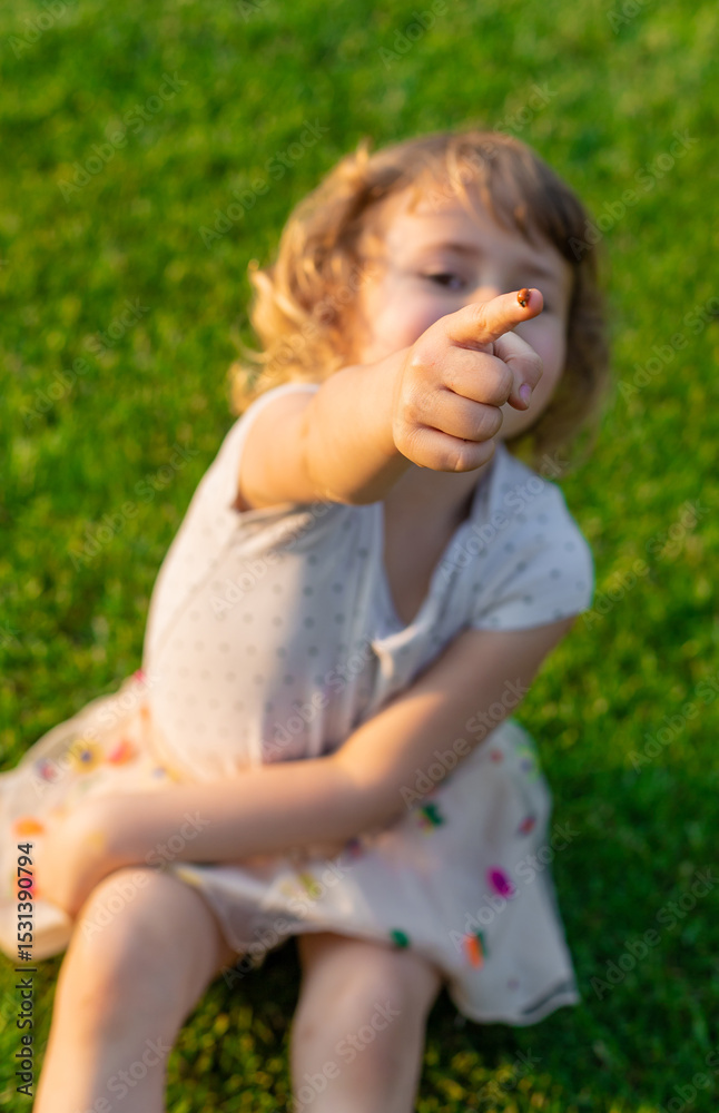 Fototapeta premium Child playing with ladybug. Selective focus.