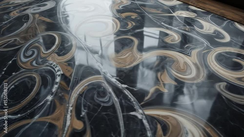 Swirling Marble Design: A Close-Up Look at Elegant Black and Gold Patterns on a Reflective Surface