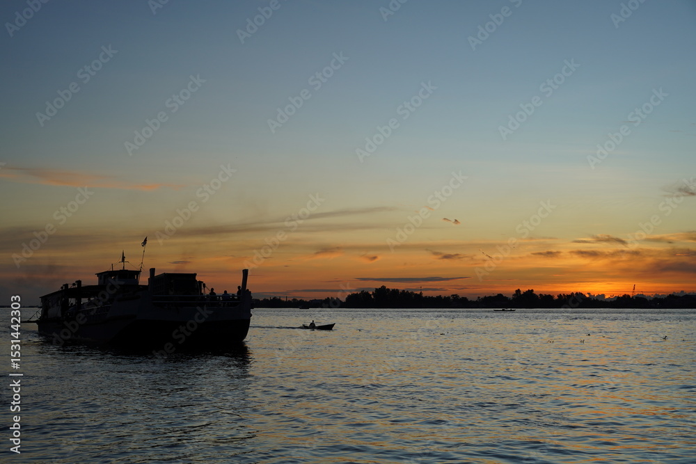 Silhouette of a Boat on Calm Water at Sunset Silhouette of a Boat on Calm Water at Sunset