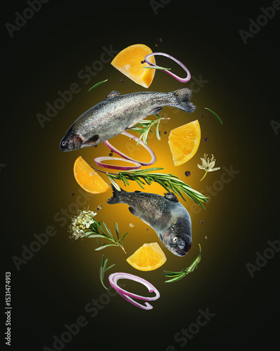 Sea trout with rosemary branches and lemon slices in the air in the dark