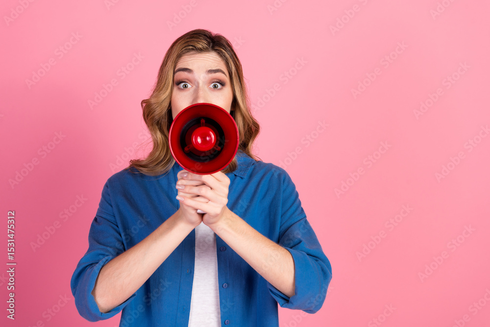 Obraz premium Young woman with surprised expression holding megaphone on bright pink background for communication, announcement, or advertising concept