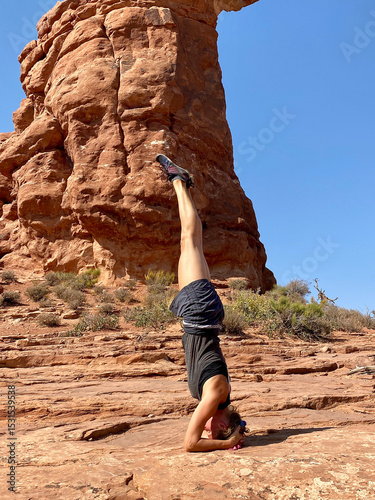 Obraz na plátně A young woman doing a yoga headstand in Moab, Utah