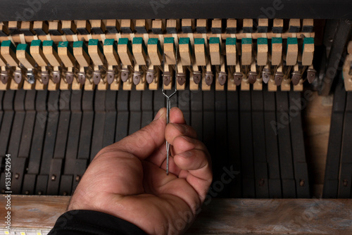 Foto closeup of hand and tools of tuner working on grand piano