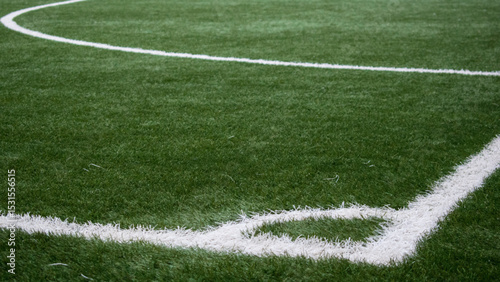 Artificial turf football field with white lines detailing corner and half circle design