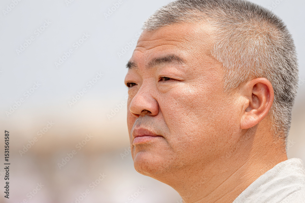 Obraz premium beach sumo wrestler portrait positioned on right side of frame with contemplative expression