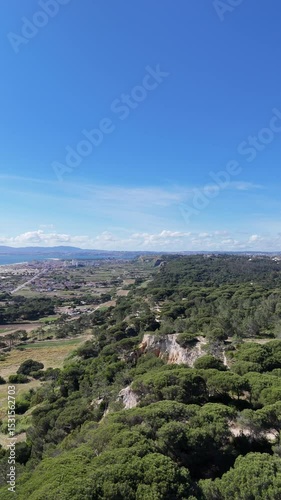 Close drone flyby along forested coastal cliffs in Portugal. Rich textures of rock and dense greenery blend with ocean backdrop. Immersive, dynamic flight with intense natural presence and detail.

