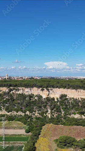 
Drone turning from beach to inland cliffs and green terrain. Flying toward textured rock formations and coastal vegetation under soft natural light. Dynamic approach with cinematic depth and contrast