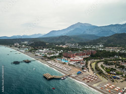 Aerial view of Kemer beach with turquoise Mediterranean sea, crystal clear water and Taurus mountains in the background, Antalya, Turkey
