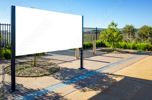 Background texture of a large, blank signboard or mockup board with bollards at the entrance of a public space. Customizable for public information or announcements from schools or company