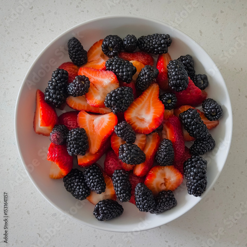 Fresh sliced strawberries and blackberries in a bowl