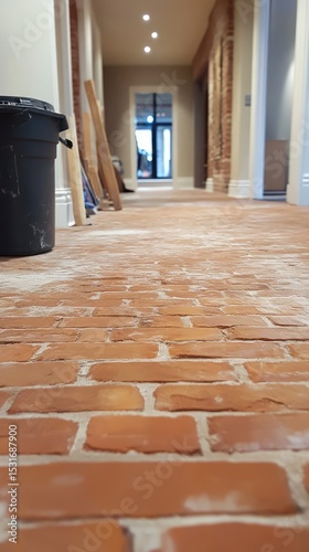 A brick floor with a black bucket in the middle