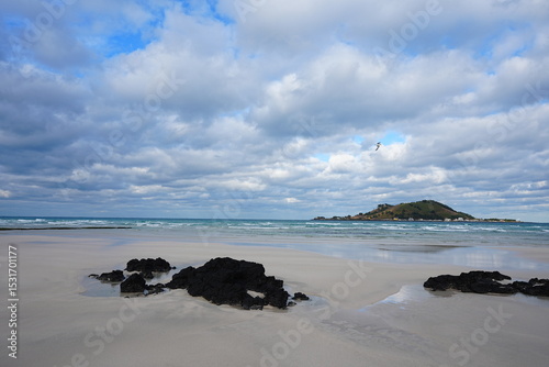 rock and sand beach and far island