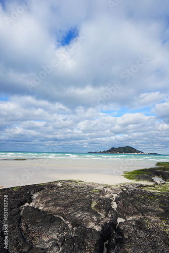 rock and sand beach and far island