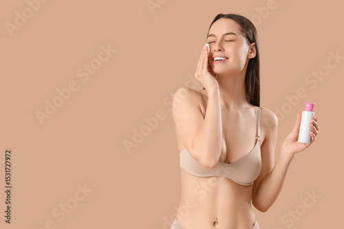 Young woman with cotton pad...