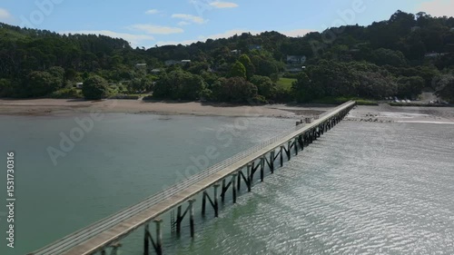 Wallpaper Mural People fishing and relaxing on a long pier over calm water in a coastal bay, enjoying the peaceful scenery in Cornwallis, Auckland, New Zealand Torontodigital.ca