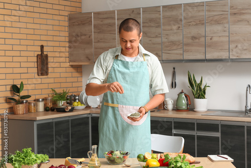 Young man spicing vegetable...