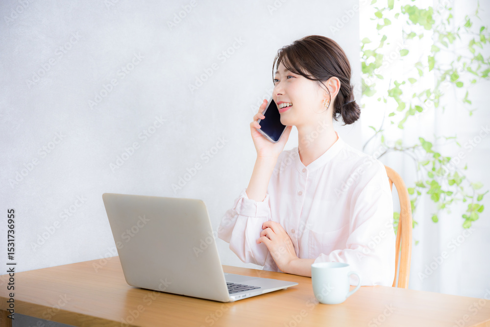 パソコンの前でスマホで通話や連絡をするコミュニケーションをとるシアーシャツのかわいい女性のビジネスシーン パソコンの前でスマホで通話や連絡をするコミュニケーションをとるシアーシャツのかわいい女性のビジネスシーン