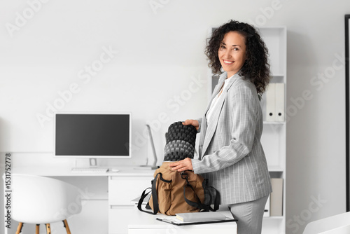 Mature businesswoman puttin...