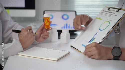 Two doctors are discussing a patient's medication and treatment plan