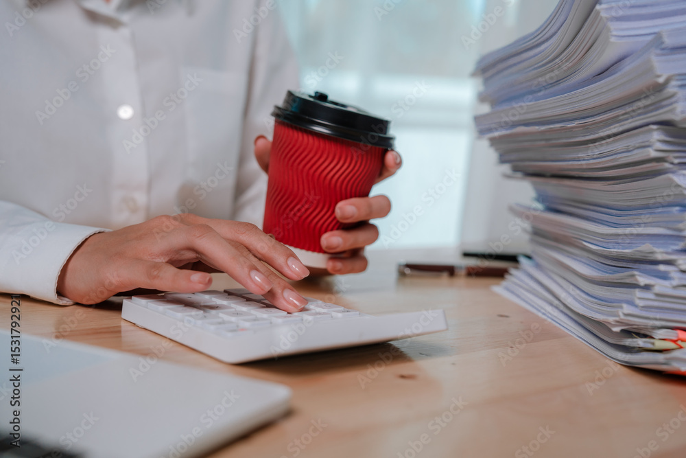 Fototapeta premium An office worker in a white shirt organizes a large stack of documents with colorful paper clips and folders.