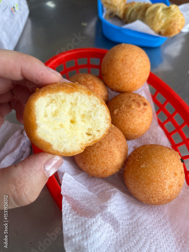 Buñuelos en Cesta Roja con Uno Mordido
