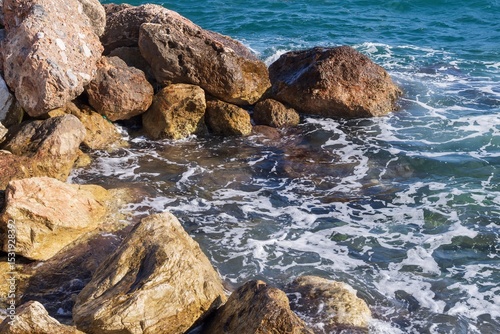 Fototapeta Naklejka Na Ścianę i Meble -  Coastal foamy waves crashing on the rocks on the Athens promenade