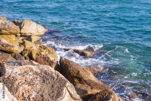 Fototapeta Naklejka Na Ścianę i Meble -  Coastal foamy waves crashing on the rocks on the Athens promenade