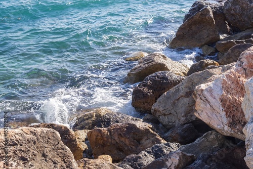 Fototapeta Naklejka Na Ścianę i Meble -  Coastal foamy waves crashing on the rocks on the Athens promenade